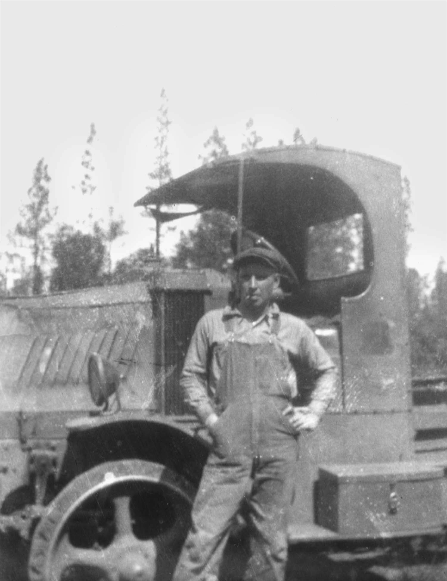 Man posing in front of logging truck